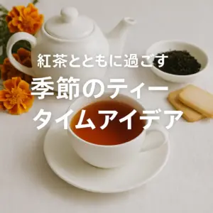 マリーゴールドの花とともに並べられたティーカップと白いティーポット、紅茶とクッキーが置かれた温かみのあるティータイムの風景